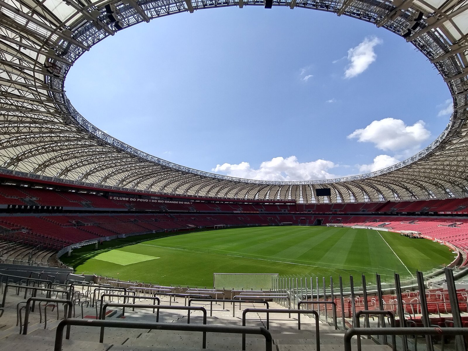 Interior do Estádio Beira-Rio, casa do Internacional, com arquibancadas vermelhas, gramado e a abertura da cobertura em 2024