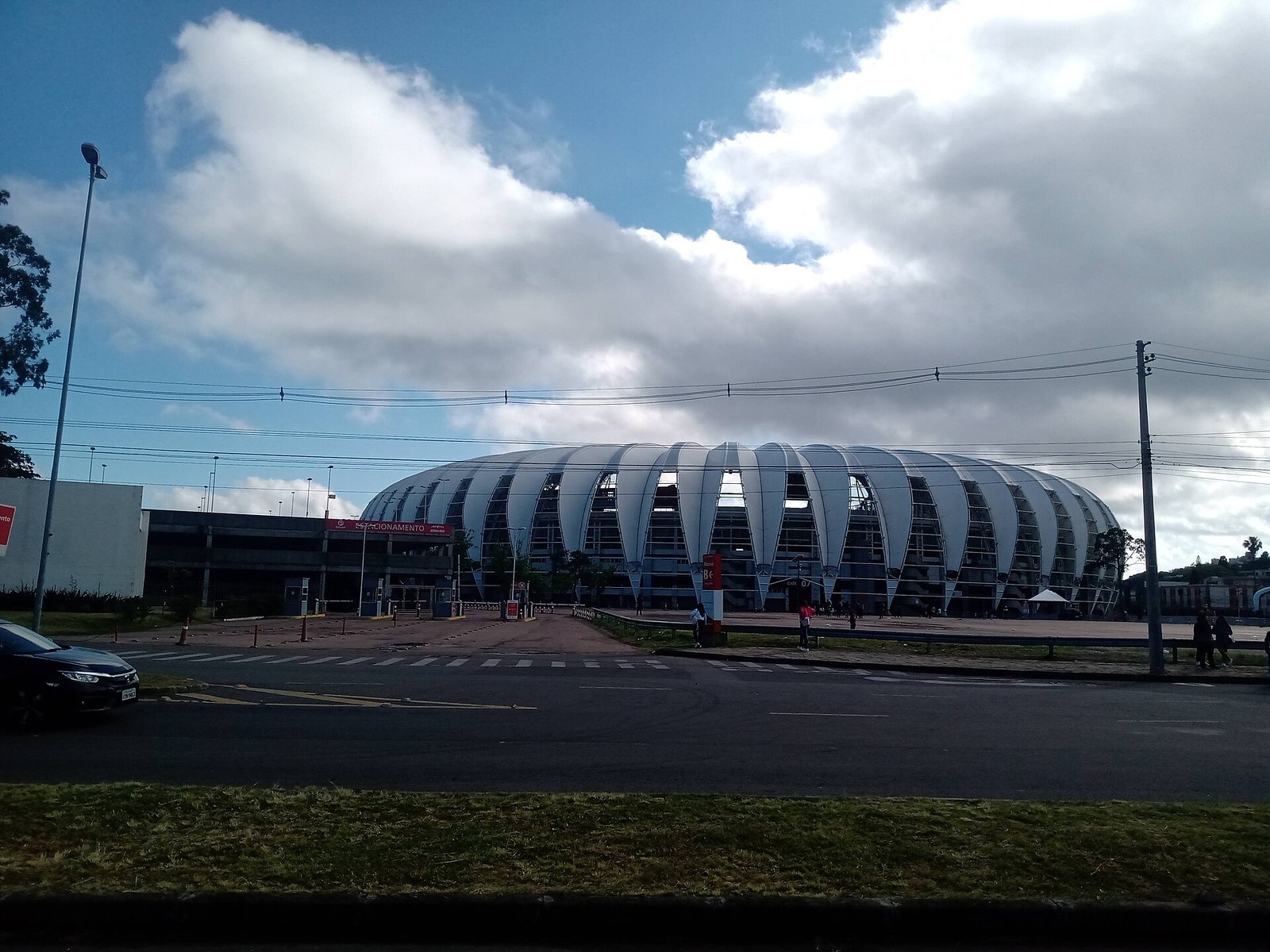 Estádio Beira-Rio, casa do Internacional, em Porto Alegre, visto de fora com a cobertura em arcos brancos sob céu nublado